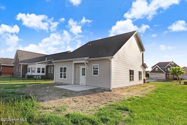 rear view of property featuring fence, a patio, and a yard
