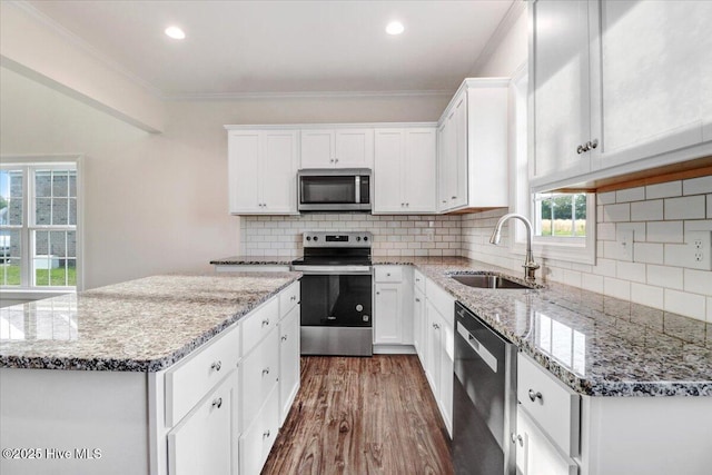 kitchen featuring a kitchen island, dark wood-type flooring, white cabinets, a sink, and stainless steel appliances