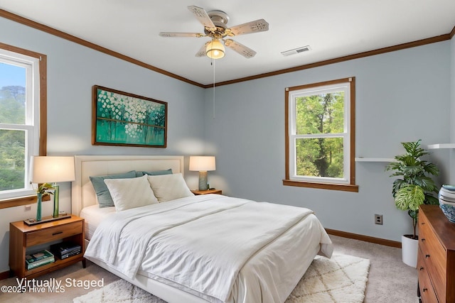 carpeted bedroom with crown molding, baseboards, visible vents, and multiple windows