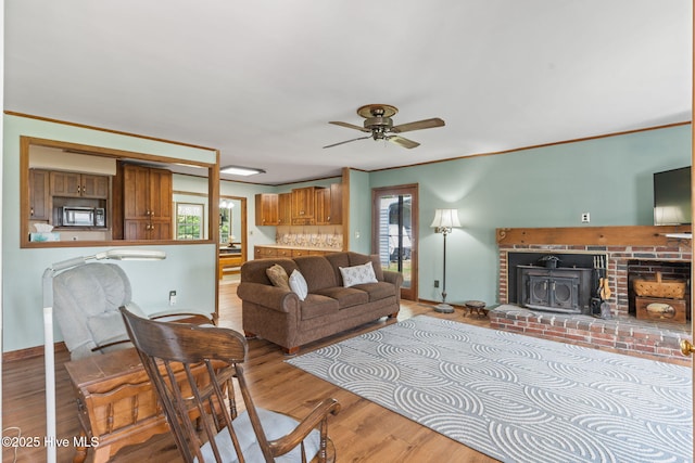 living area with a ceiling fan, wood finished floors, and a wealth of natural light