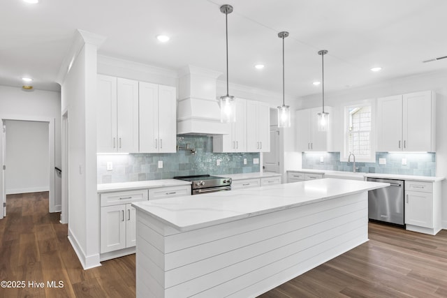 kitchen with appliances with stainless steel finishes, backsplash, a kitchen island, visible vents, and custom exhaust hood