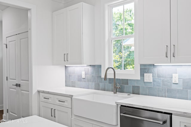 kitchen featuring a sink, white cabinetry, dishwasher, and decorative backsplash
