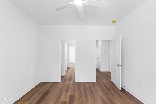 unfurnished bedroom featuring a ceiling fan, baseboards, and dark wood-type flooring