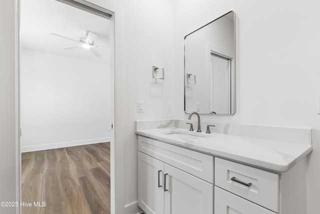 bathroom featuring vanity, a ceiling fan, baseboards, and wood finished floors