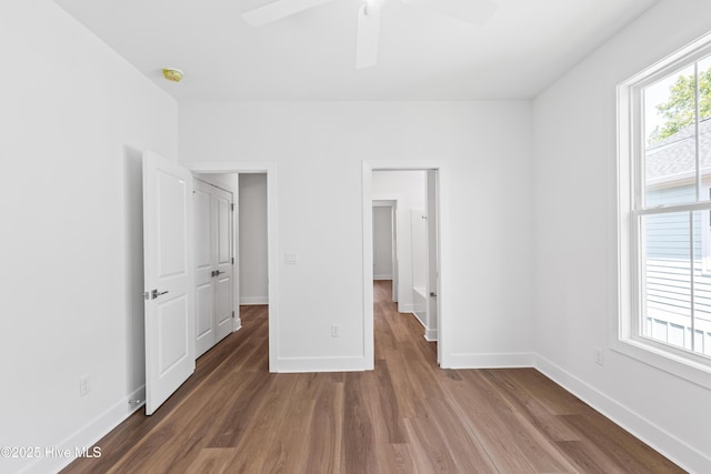 unfurnished bedroom featuring baseboards, a ceiling fan, and wood finished floors