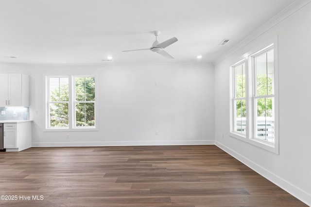 unfurnished room featuring crown molding, baseboards, visible vents, and a healthy amount of sunlight