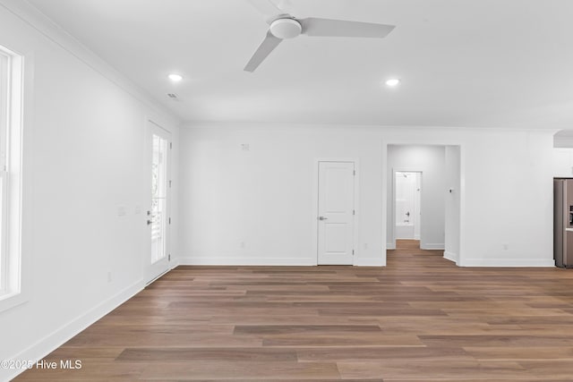 empty room with crown molding, baseboards, ceiling fan, and wood finished floors