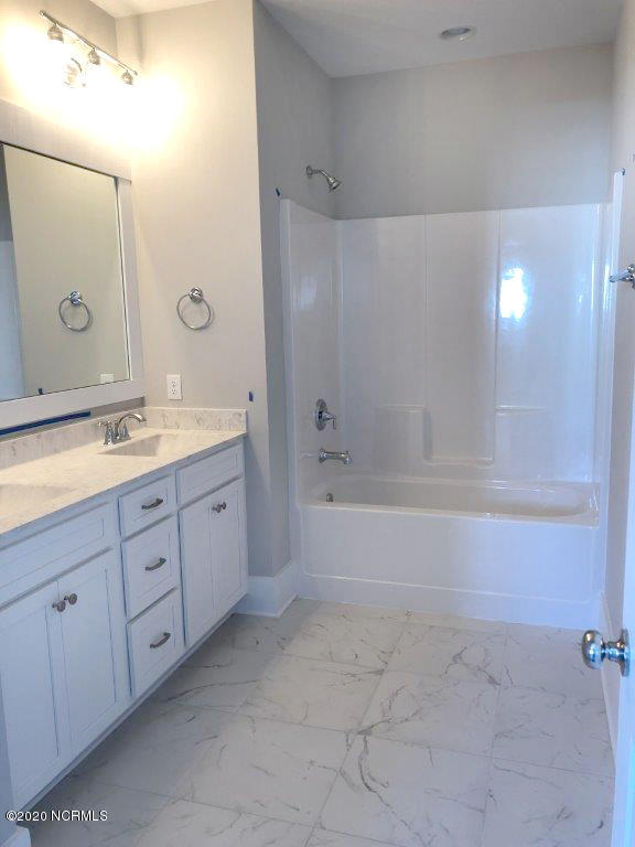 4006 Tamarisk Ln, Wilmington, NC 28409 - bathroom featuring double vanity, a sink, baseboards,  shower combination, and marble finish floor