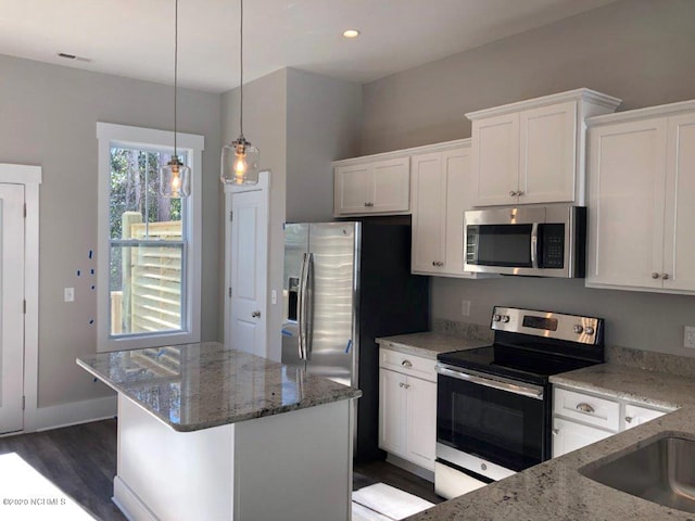 4006 Tamarisk Ln, Wilmington, NC 28409 - kitchen with dark wood finished floors, white cabinets, light stone countertops, and stainless steel appliances