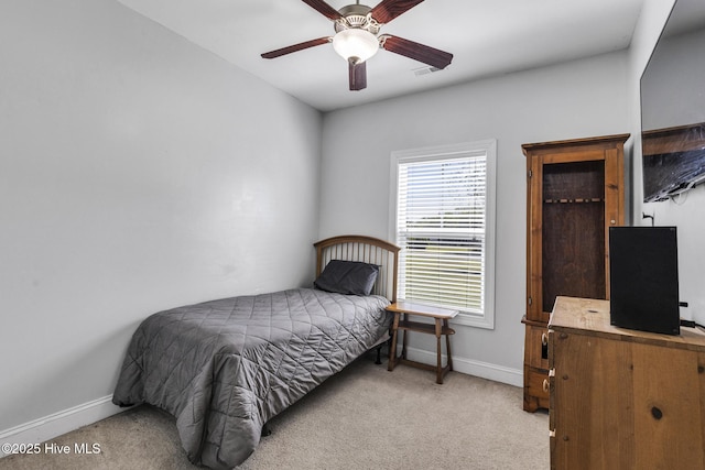bedroom with baseboards, ceiling fan, and light carpet