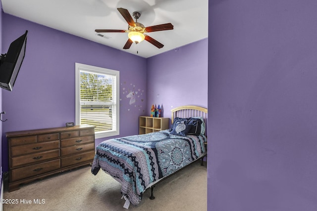 carpeted bedroom featuring a ceiling fan and visible vents