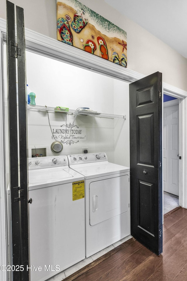 clothes washing area with dark wood-style flooring, separate washer and dryer, and laundry area