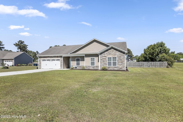 view of front of home featuring a garage, fence, a front yard, stone siding, and driveway