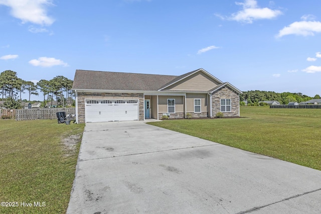 view of front facade with a front yard, a garage, fence, concrete driveway, and stone siding