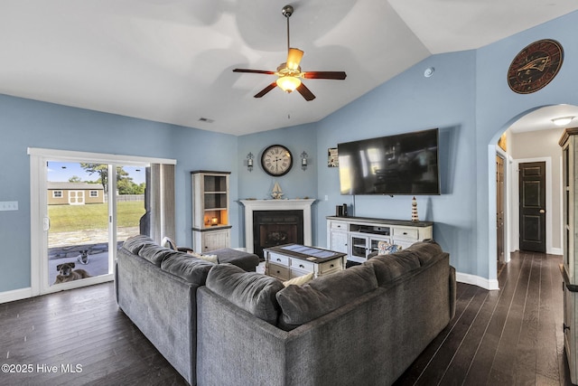 living area featuring arched walkways, ceiling fan, lofted ceiling, and dark wood-type flooring
