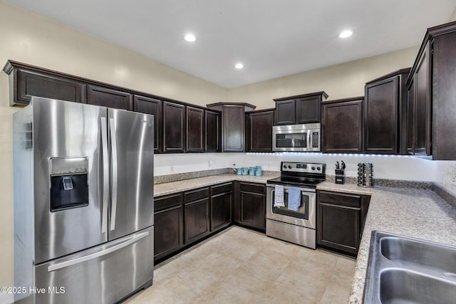 kitchen with a sink, dark brown cabinetry, stainless steel appliances, and recessed lighting