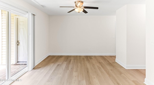 spare room with ceiling fan, light wood-style floors, and baseboards