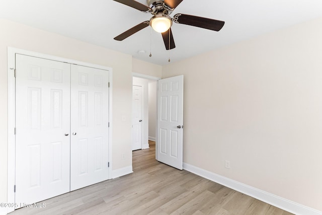 unfurnished bedroom with light wood-style flooring, baseboards, a closet, and a ceiling fan