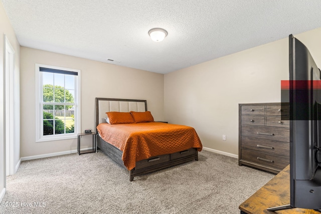 carpeted bedroom featuring visible vents, a textured ceiling, and baseboards