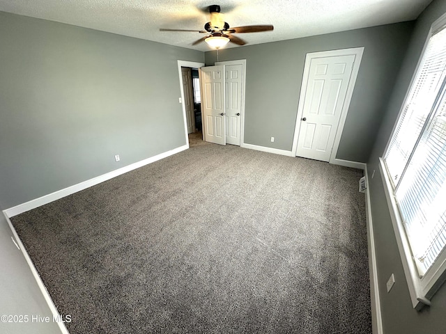 unfurnished bedroom with baseboards, carpet, a ceiling fan, and a textured ceiling