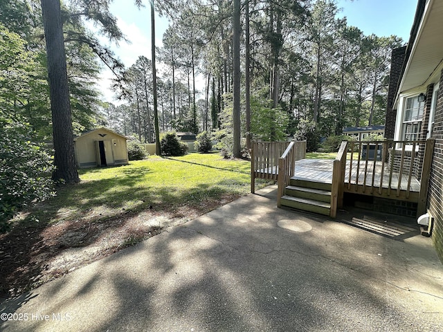 view of yard with a storage unit, an outdoor structure, a patio area, and a wooden deck