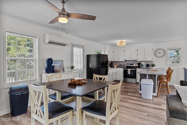 dining space with a ceiling fan, a wall mounted AC, a wealth of natural light, and light wood-style floors
