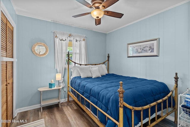 bedroom with crown molding, baseboards, ceiling fan, and wood finished floors
