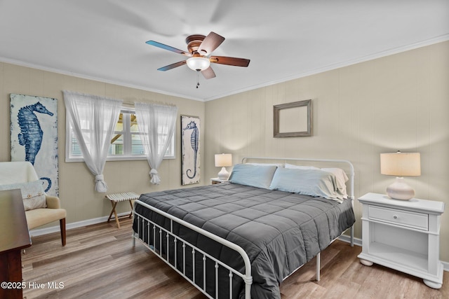 bedroom with crown molding, baseboards, a ceiling fan, and wood finished floors