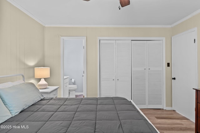 bedroom featuring connected bathroom, a ceiling fan, wood finished floors, ornamental molding, and a closet