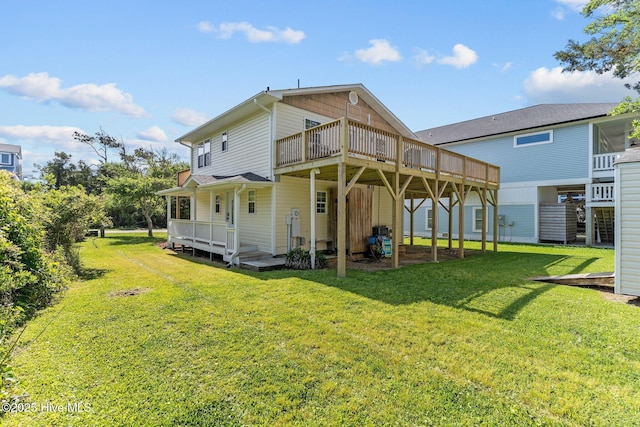 rear view of property featuring a lawn and a wooden deck