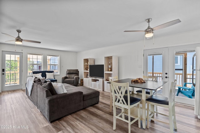 living area with a ceiling fan, french doors, and wood finished floors