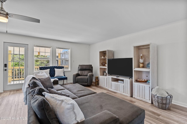 living room featuring a ceiling fan, baseboards, plenty of natural light, and light wood-style floors