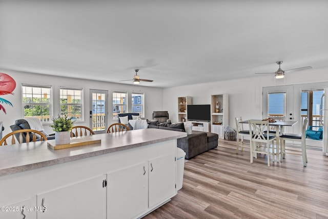 kitchen with white cabinets, a ceiling fan, plenty of natural light, and light wood finished floors