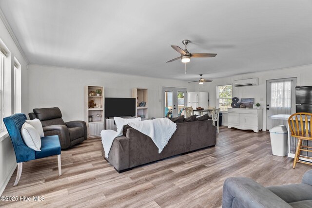 living room featuring ceiling fan, a wall mounted air conditioner, and wood finished floors