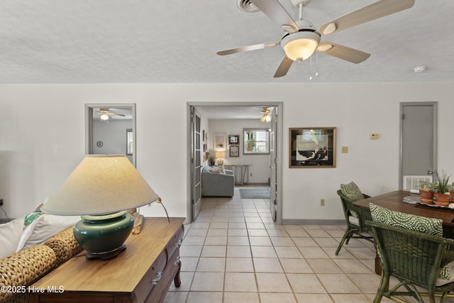 116 SE 8th St, Oak Island, NC 28465 - interior space featuring a textured ceiling, baseboards, a ceiling fan, and light tile patterned floors