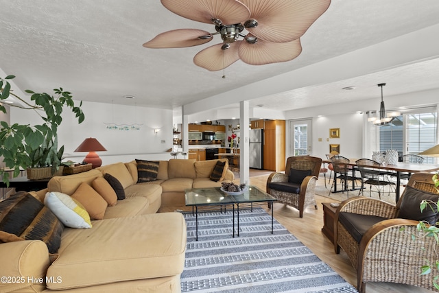 116 SE 8th St, Oak Island, NC 28465 - living area featuring a textured ceiling, a wealth of natural light, ceiling fan with notable chandelier, and light wood-type flooring