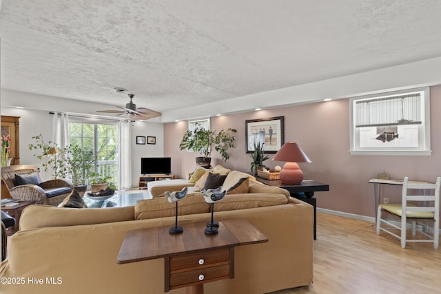 116 SE 8th St, Oak Island, NC 28465 - living room with a ceiling fan, baseboards, light wood-style flooring, and a textured ceiling