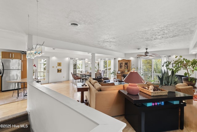 116 SE 8th St, Oak Island, NC 28465 - living area with a textured ceiling, visible vents, light wood-style flooring, and ceiling fan