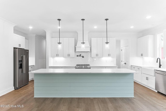 322 NE 50th St, Oak Island, NC 28465 - kitchen with a center island, tasteful backsplash, custom range hood, a sink, and appliances with stainless steel finishes