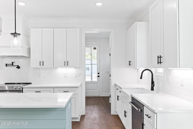 322 NE 50th St, Oak Island, NC 28465 - kitchen with white cabinets, backsplash, appliances with stainless steel finishes, and a sink
