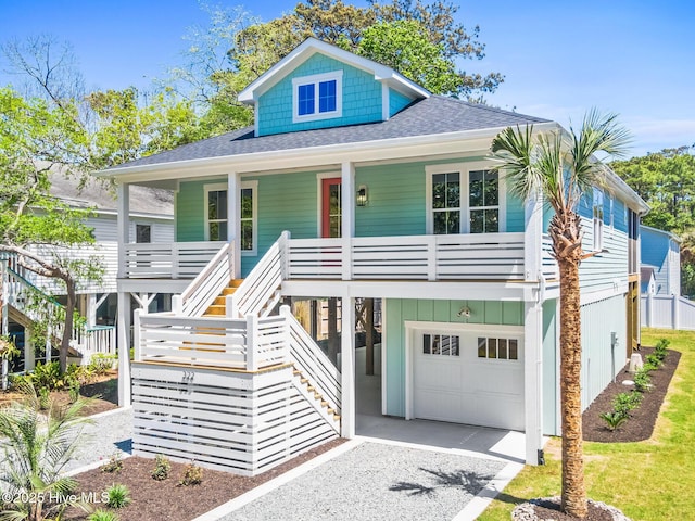 322 NE 50th St, Oak Island, NC 28465 - raised beach house with stairway, covered porch, roof with shingles, and gravel driveway
