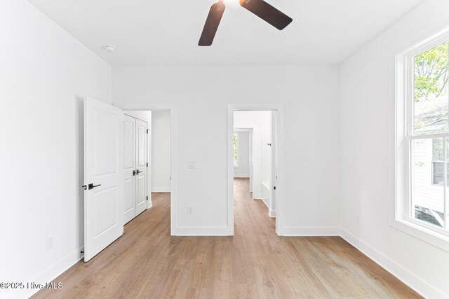 322 NE 50th St, Oak Island, NC 28465 - unfurnished bedroom with baseboards, a ceiling fan, and light wood-style flooring