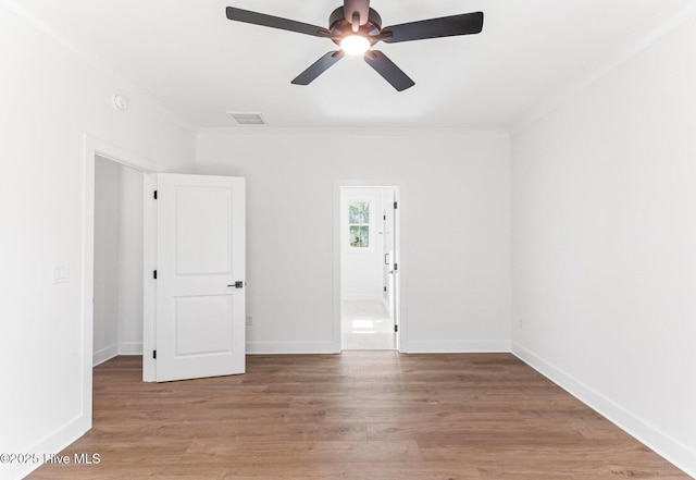 322 NE 50th St, Oak Island, NC 28465 - spare room with visible vents, crown molding, wood finished floors, and ceiling fan