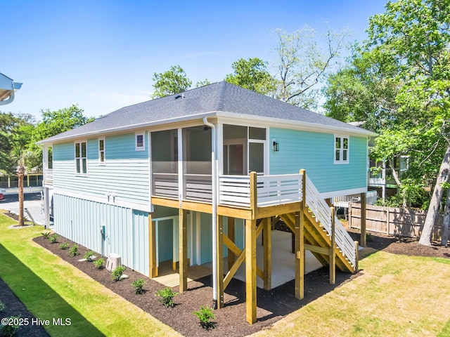 322 NE 50th St, Oak Island, NC 28465 - back of house featuring stairway, roof with shingles, a sunroom, and a lawn