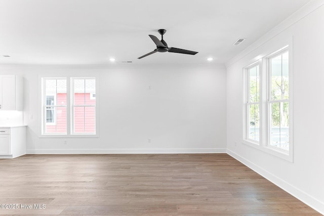 322 NE 50th St, Oak Island, NC 28465 - spare room featuring baseboards, ornamental molding, light wood-style flooring, and a ceiling fan