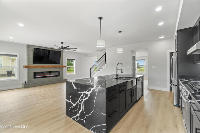 149 Pelican Pointe Dr, Elizabeth City, NC 27909 - kitchen with ceiling fan, a kitchen island with sink, appliances with stainless steel finishes, a sink, and dark cabinets