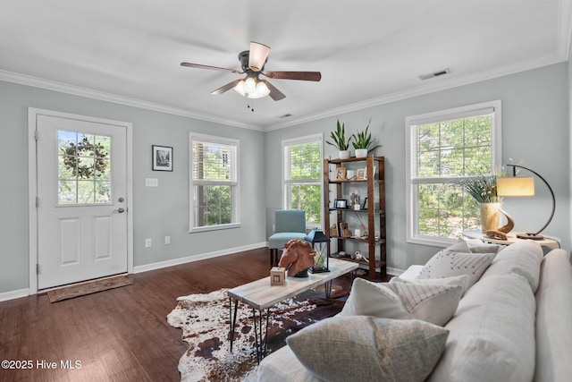 living area with visible vents, ornamental molding, a healthy amount of sunlight, and wood finished floors