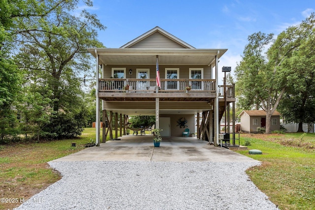 1326 Burnett Rd, Wilmington, NC 28409 - coastal home featuring gravel driveway, a carport, a front lawn, and a porch