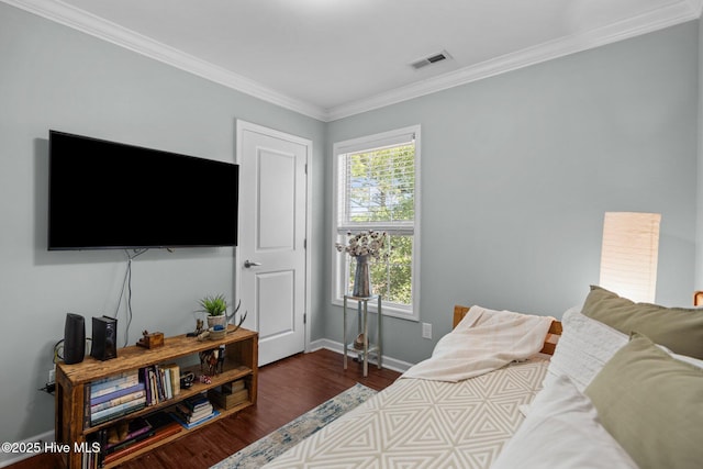 bedroom featuring baseboards, ornamental molding, dark wood-style flooring, and visible vents