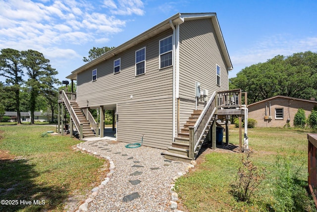 view of front of property featuring a deck, a front lawn, and stairway